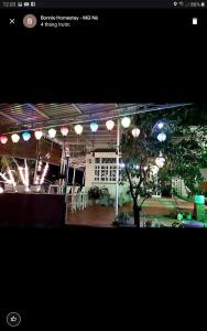 a room with lights and a building with a tree at BONNIE HOMESTAY Mui Ne in Mui Ne