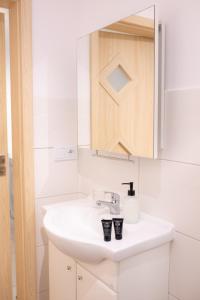 a bathroom with a white sink and a mirror at Domek na Lipowej in Stare Miasto