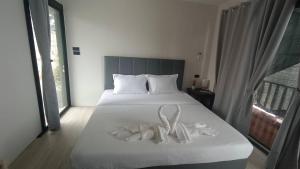 a bedroom with a bed with two white towels on it at ธัญญ์ รีสอร์ท หินดาด in Ban Pak Nam Chumphon