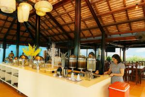 Anna Beach Resort and Restaurant في Ấp Long Sơn: امرأة تقف أمام كونتر مع الطعام