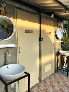 a bathroom with a toilet and a sink in a trailer at Shah Hill Hut in Phra Ae beach