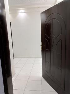 an open door in a room with a white tile floor at مكة المكرمة وادي جليل in As Sifyānī
