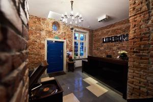 a hallway with a blue door and a brick wall at Liberum Residence Old Town in Gdańsk