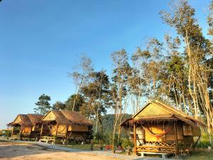 two huts with thatched roofs in a forest at Shah Hill Hut in Phra Ae beach