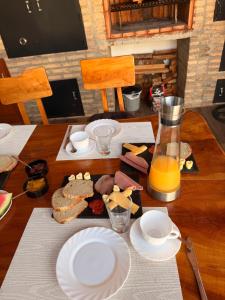 a table with plates of food and a jug of orange juice at Casa Stiller in Itá