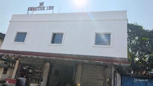 a white building with two windows on top of it at Swastiik Inn 