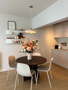 une table de salle à manger avec un vase de fleurs dessus dans l'établissement Windekind402, à La Panne 33 autres photos