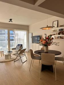 un salon avec une table et des chaises de salle à manger dans l'établissement Windekind402, à La Panne