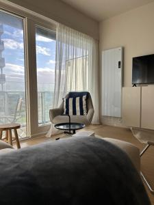 un salon avec un canapé et une chaise et une grande fenêtre dans l'établissement Windekind402, à La Panne