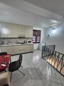 a kitchen with white cabinets and a table and a chair at Olive Home in Yerevan +4 photos