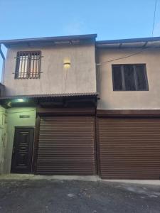 a building with two garage doors on the side of it at Olive Home in Yerevan