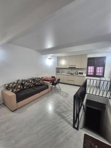 a living room with a couch and a kitchen at Olive Home in Yerevan