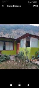 a green house with a door in front of it at Wonderful Full House in Ollantaytambo