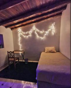 a bedroom with a bed with lights on the wall at Wonderful Full House in Ollantaytambo