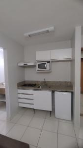Una cocina blanca con fregadero y microondas. en Boulevard suite hotel suite 434, en Caldas Novas