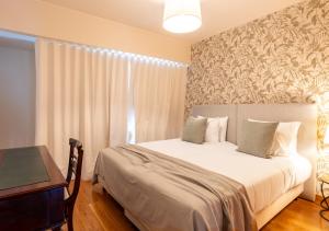 una camera da letto con un letto con un tavolo e una finestra di Funcho 91 - Spacious 100m2 Apt - Panoramic Views - Free Parking - Madeira a Funchal