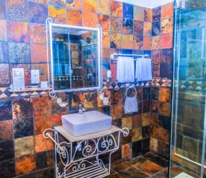 a bathroom with a sink and a mirror at Manong Game Lodge in Lobatse +44 photos