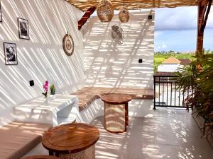 a patio with two tables and two stools at D'rei guesthouse in Canggu