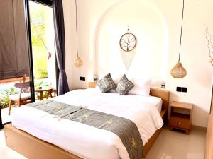 a bedroom with a large bed with a large window at D'rei guesthouse in Canggu +24 photos