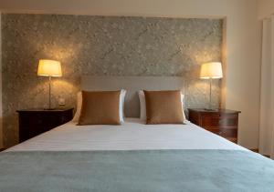 una camera da letto con un grande letto e due lampade di Funcho 91 - Spacious 100m2 Apt - Panoramic Views - Free Parking - Madeira a Funchal