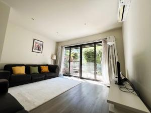 Una sala de estar con un sofá negro y un televisor. en Spacious Family Townhouse near Kingston & Manuka, en Fyshwick