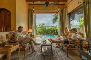 een groep mensen die in een woonkamer zitten bij EKOSTAY - Peach Grove Villa - 3kms away from Calangute and Baga Beach in Arpora