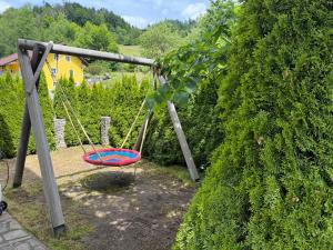 a swing in a garden next to a bush at Haus Leiner 