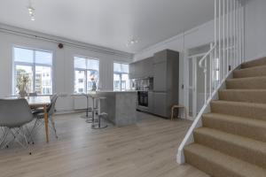 Una cocina y sala de estar con escaleras y una mesa. en Two story townhouse apartment in old town Reykjavik, en Reikiavik