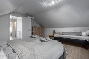 Dos camas en una habitación con paredes blancas. en Two story townhouse apartment in old town Reykjavik, en Reikiavik