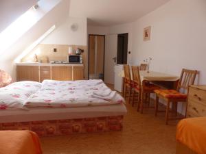 a bedroom with a bed and a kitchen with a table at Bizoní dvůr in Řetenice