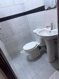 a bathroom with a toilet and a sink at Kent One Hotel in Fort Portal