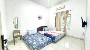 Postel nebo postele na pokoji v ubytování Homey Guesthouse Gubeng Syariah