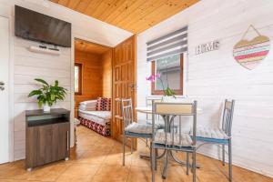 科乌切沃Domki Daglezja的一间带桌椅和电视的餐厅