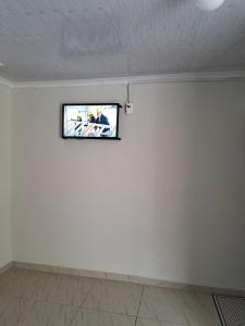 Nexus Guest House Alberton في ألبرتون: تلفزيون على جدار غرفة بيضاء
