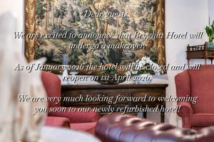 a living room with red chairs and a fireplace at Hotel Bryghia in Bruges