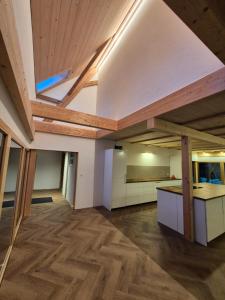 an empty room with wood floors and a ceiling at Kleine Heubühne im Emmental mit 2 Schlafzimmer und 2 Schlafsofas in Rüegsbach +6 photos