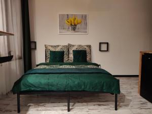 a bedroom with a bed with green sheets and yellow flowers at Apartamenty Królówka in Bydgoszcz