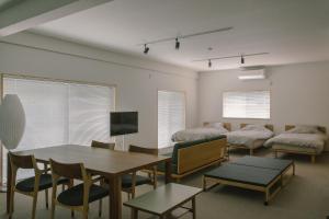 a room with a dining table and a room with beds at Stay Okumatsusaka in Matsuzaka