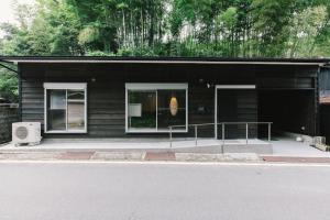 a black house with two windows and a balcony at Stay Okumatsusaka in Matsuzaka