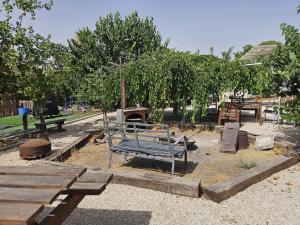 a park with a bench and tables and trees at חאן בשביל היער in Ta‘oz