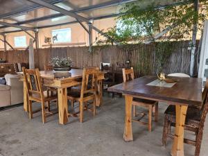 a group of wooden tables and chairs in a patio at חאן בשביל היער in Ta‘oz