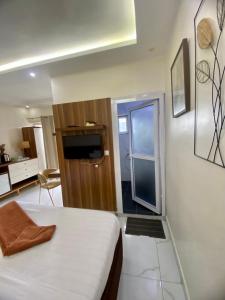 a bedroom with a bed and a door to a kitchen at Chambre meublée - Bonapriso in Douala +8 photos
