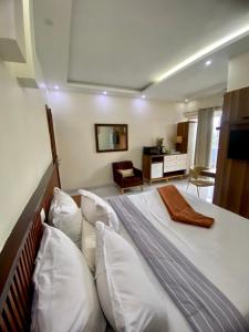 a bedroom with a large bed with white pillows at Chambre meublée - Bonapriso in Douala