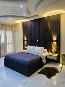 a bedroom with a large bed with a blue comforter at Chambre meublée - Bonapriso in Douala