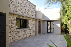 Una fachada de piedra de una casa con entrada para coches. en Villa Blanca - Pureté & Modernité, en Essaouira