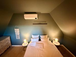 a bedroom with a bed with two night stands and two lamps at Duplex neuf et cosy vue Mont des Cats in Météren