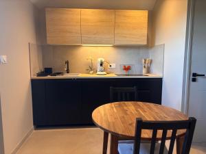 a kitchen with a wooden table and a kitchen counter at Duplex neuf et cosy vue Mont des Cats in Météren