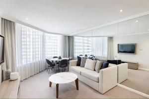 una sala de estar con un sofá y una mesa en Modern Apartments Step from Quay west Sebel, en Sídney