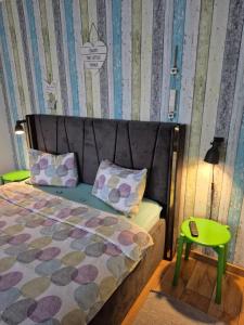 a bedroom with a bed and a green stool at Dream Studio Petrosani in Petroşani