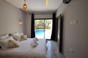 Un dormitorio con una cama blanca con toallas. en Villa Blanca - Pureté & Modernité, en Essaouira 36 fotos más